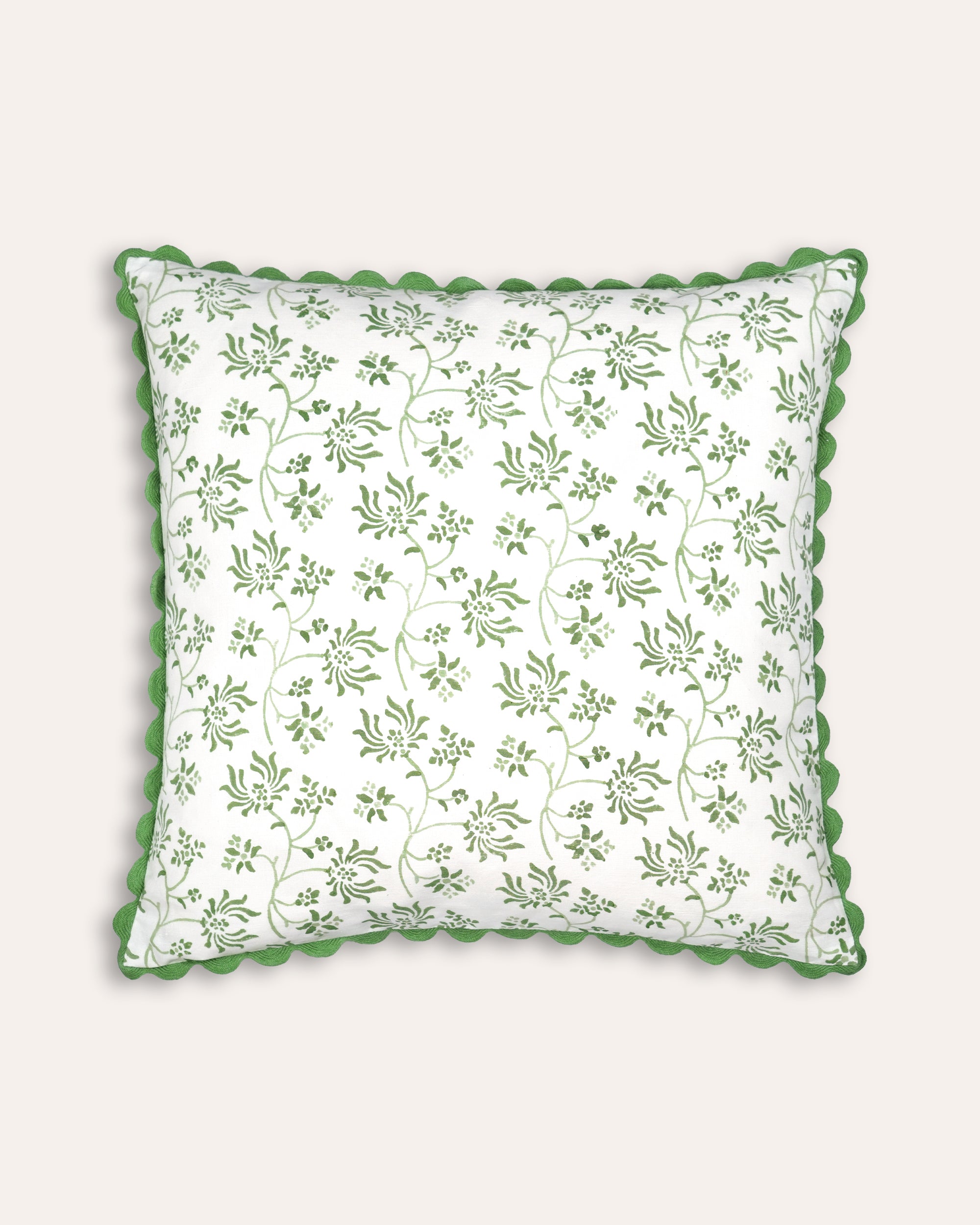 Decorative square cushion with green floral pattern on a white background
