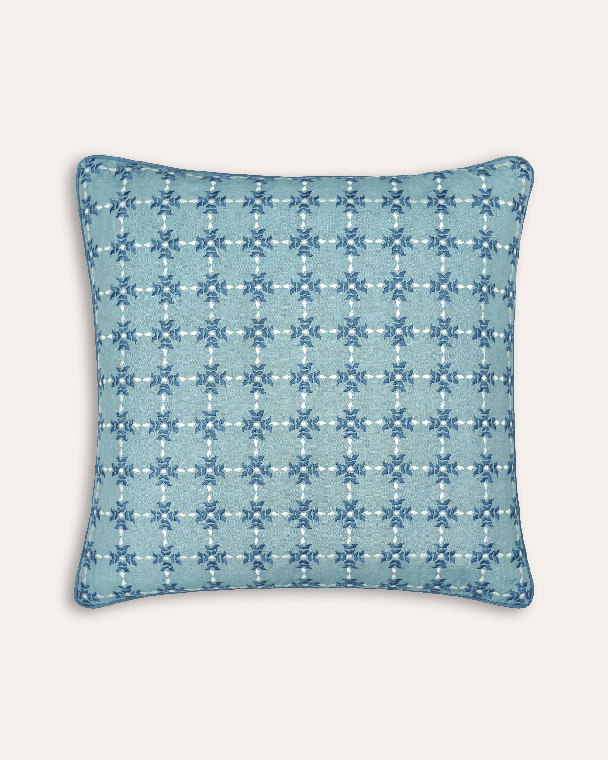 Decorative square cushion with blue geometric pattern on a light blue background