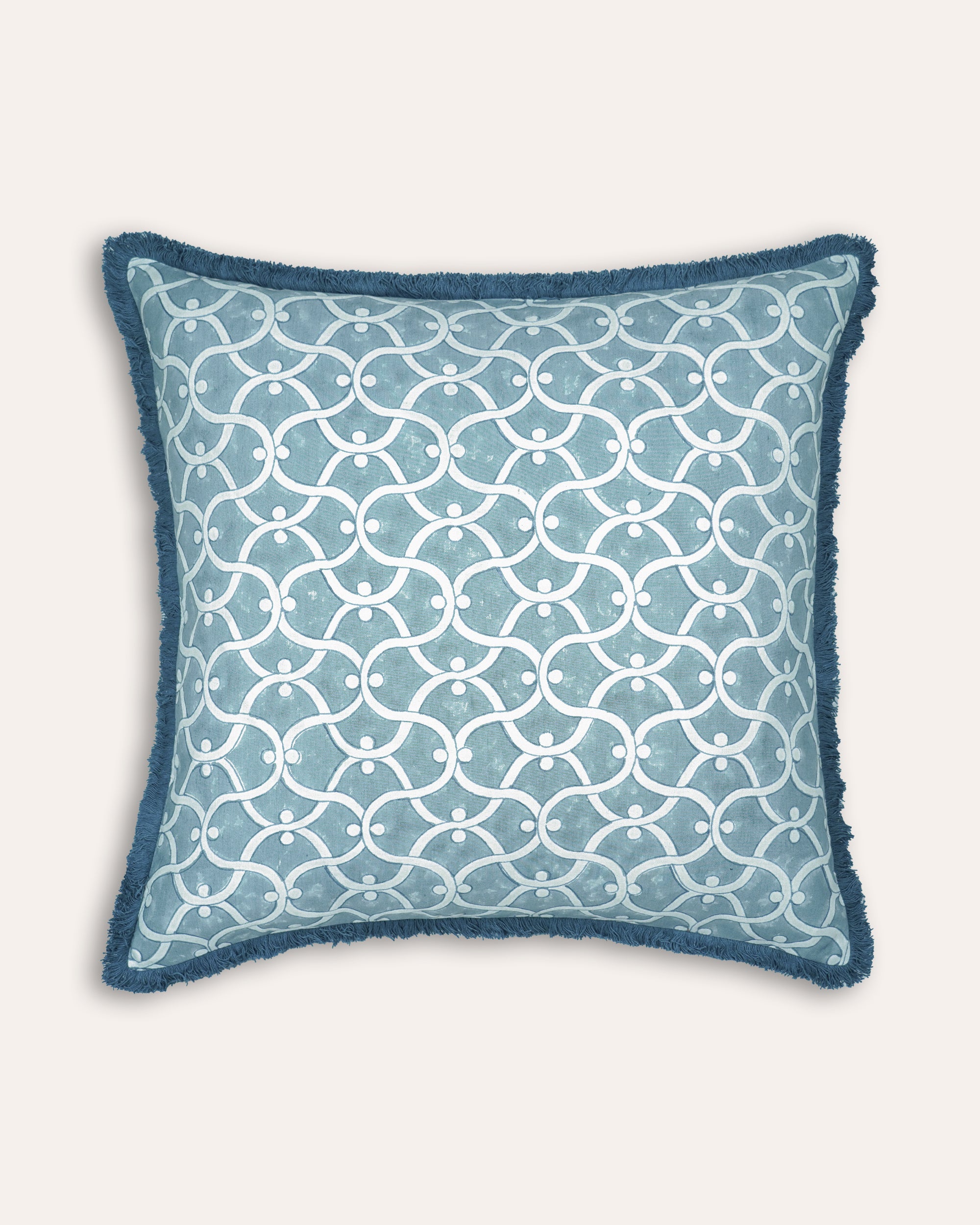 Decorative block printed square cushion with blue and white geometric pattern on a white background