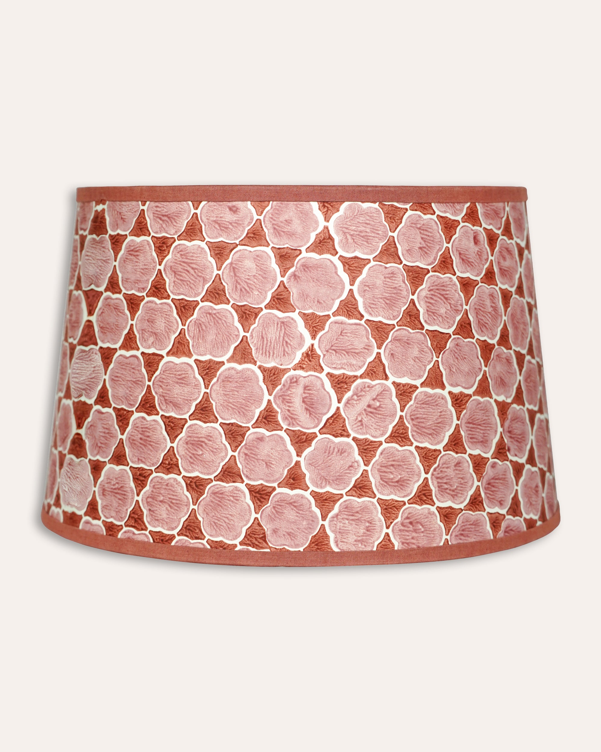 Pink and red lampshade with geometric pattern on a white background