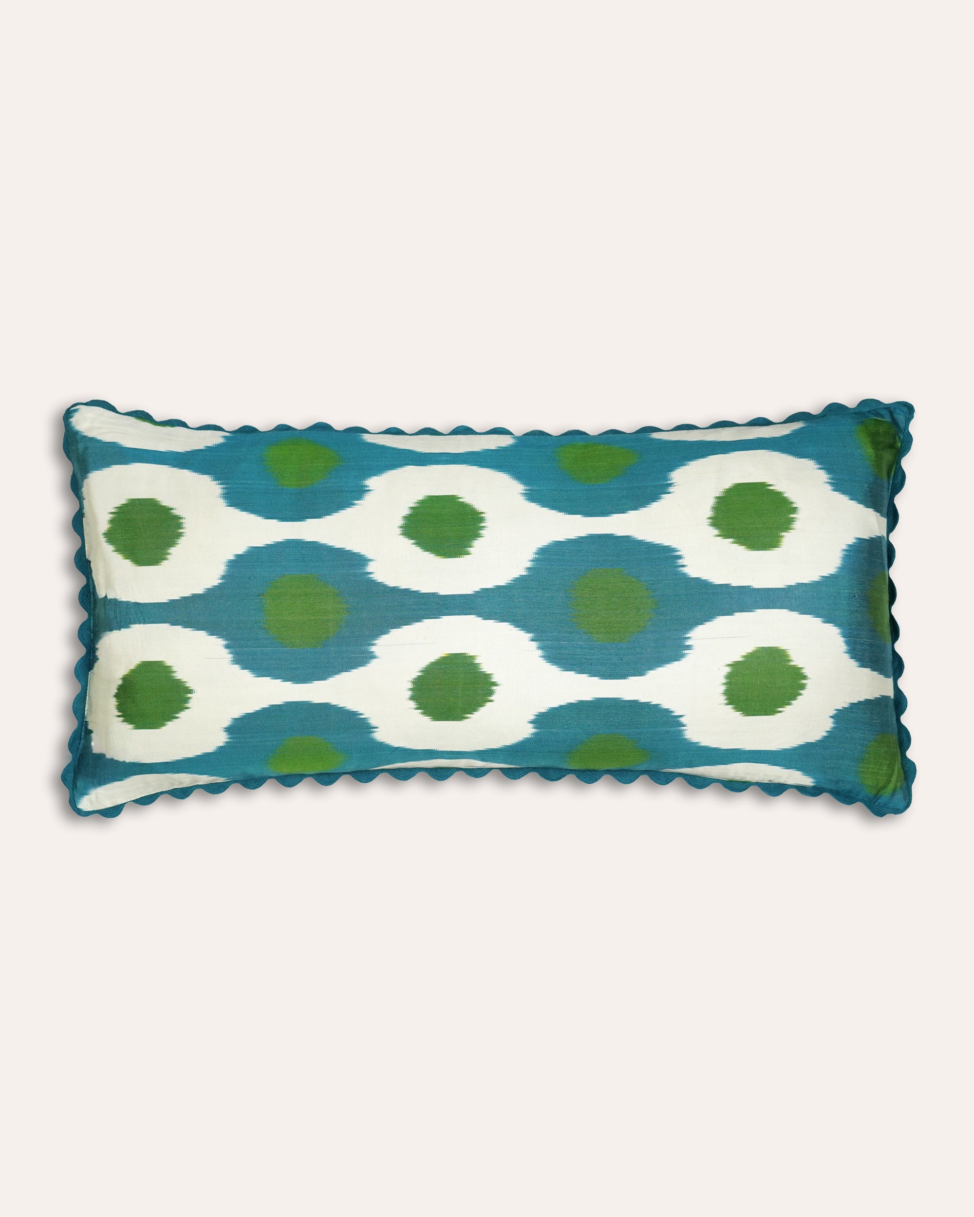 Blue, green and taupe patterned rectangular ikat cushion with a scalloped edging