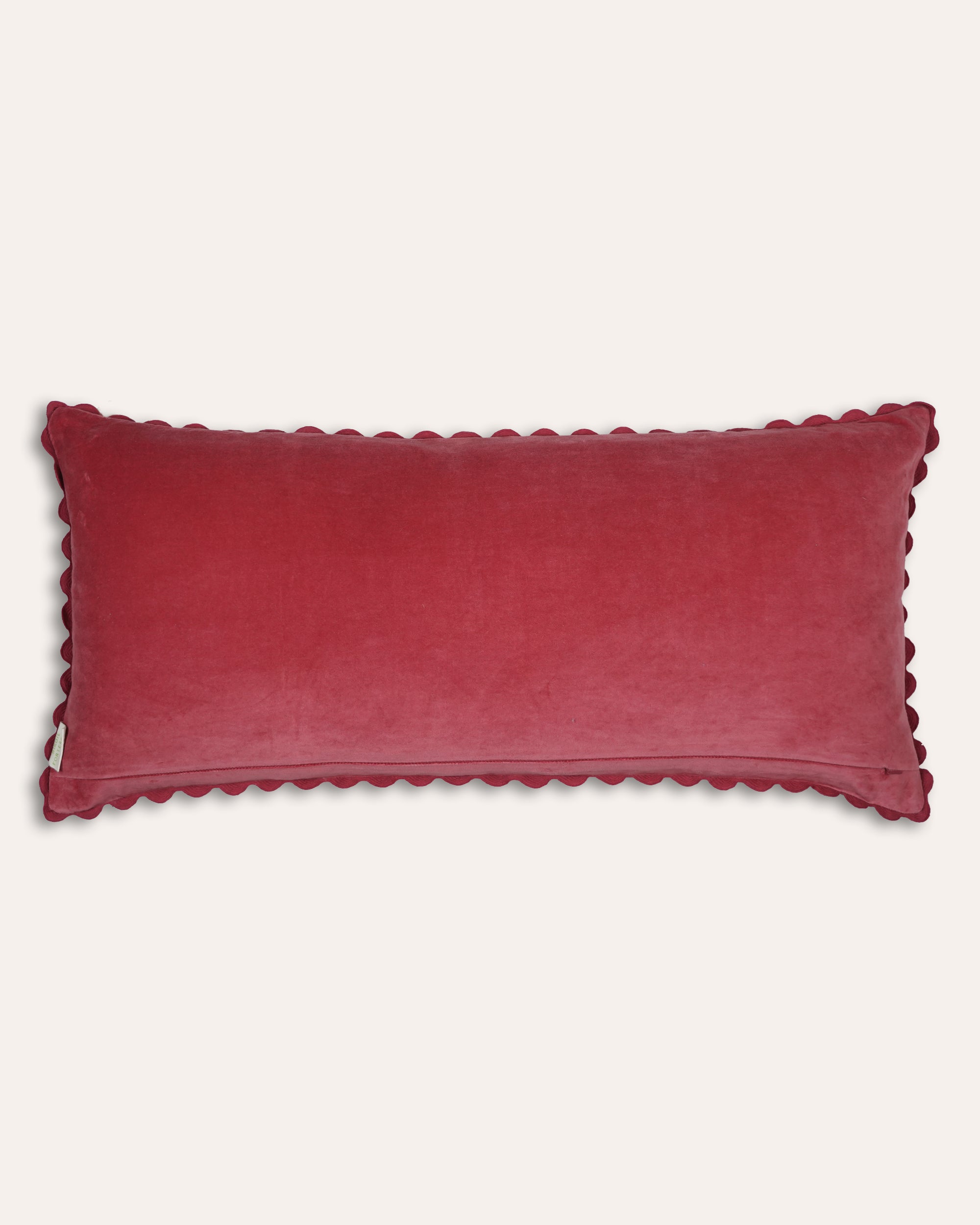 Large red velvet cushion back with scalloped edge on a light grey background