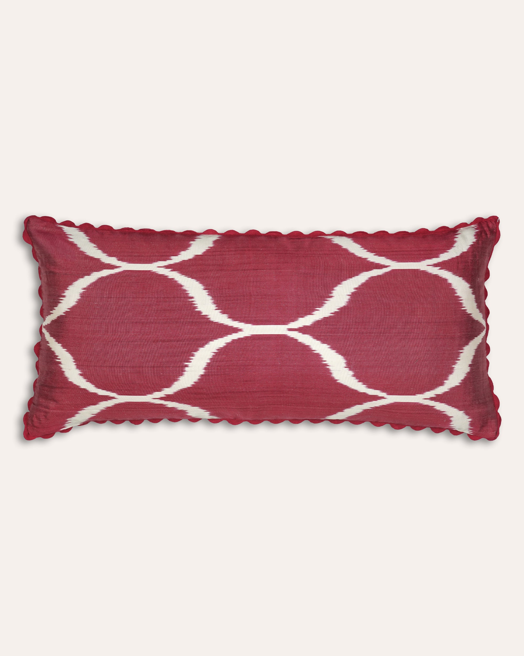 Large red rectangular cushion with white geometric pattern on a white background