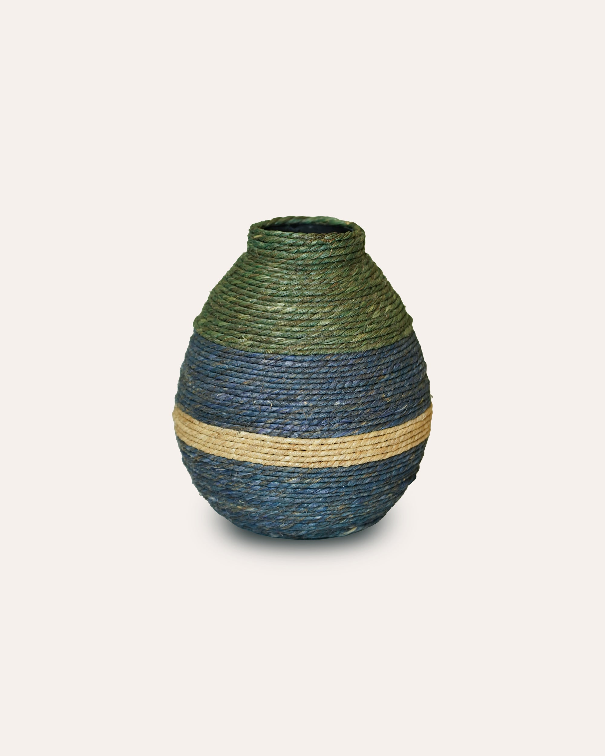 Woven vase with green and blue pattern on a light white background