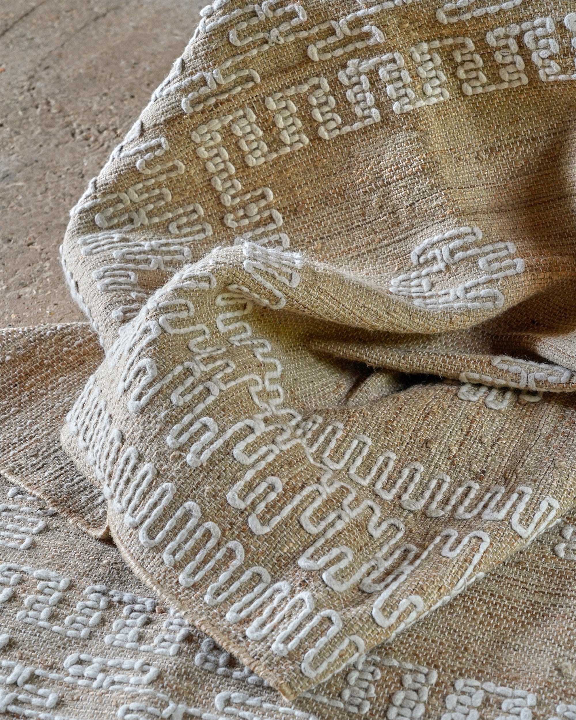 Close-up of a textured fabric with a geometric pattern on a beige background