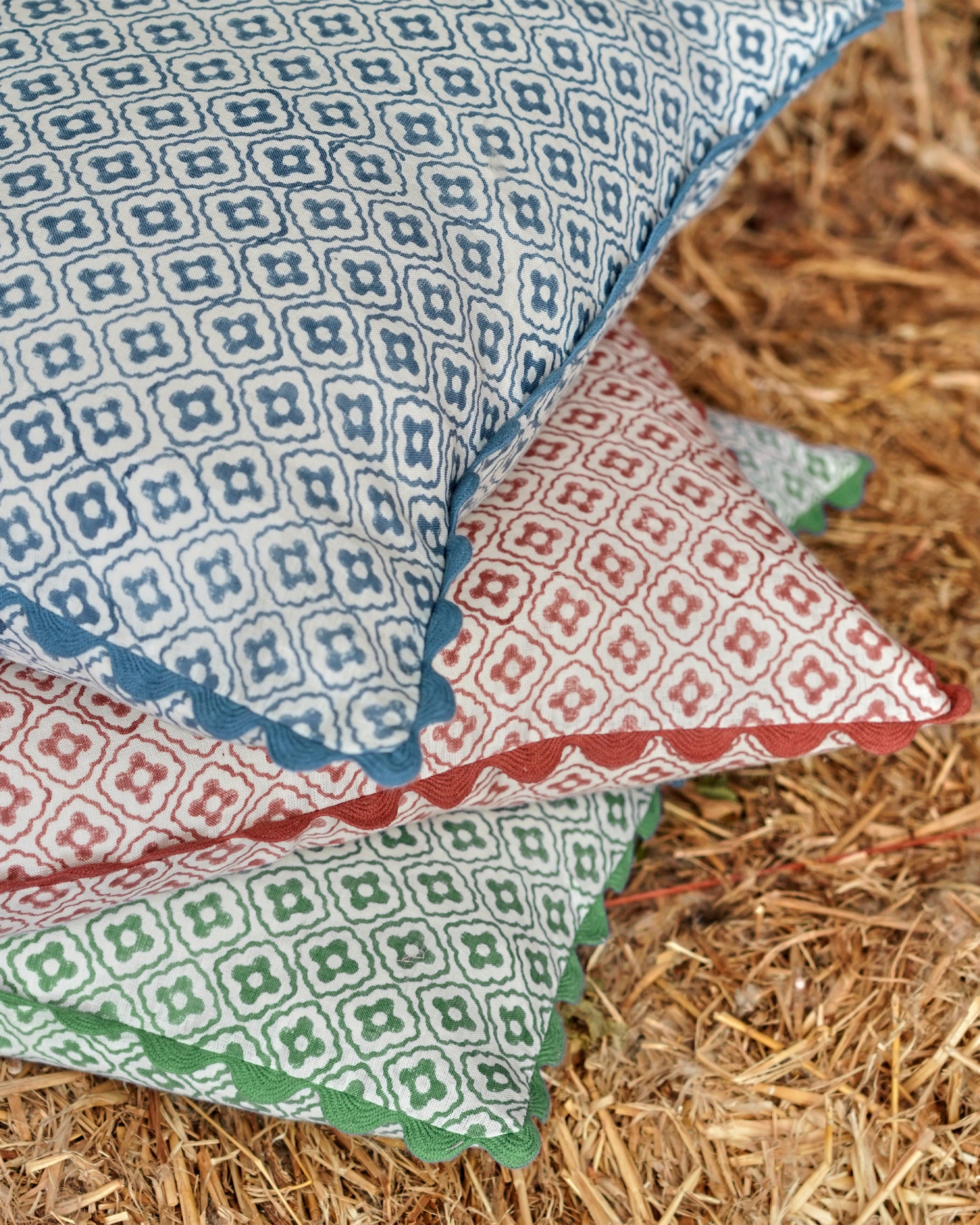 Stack of patterned pillows on a hay bale