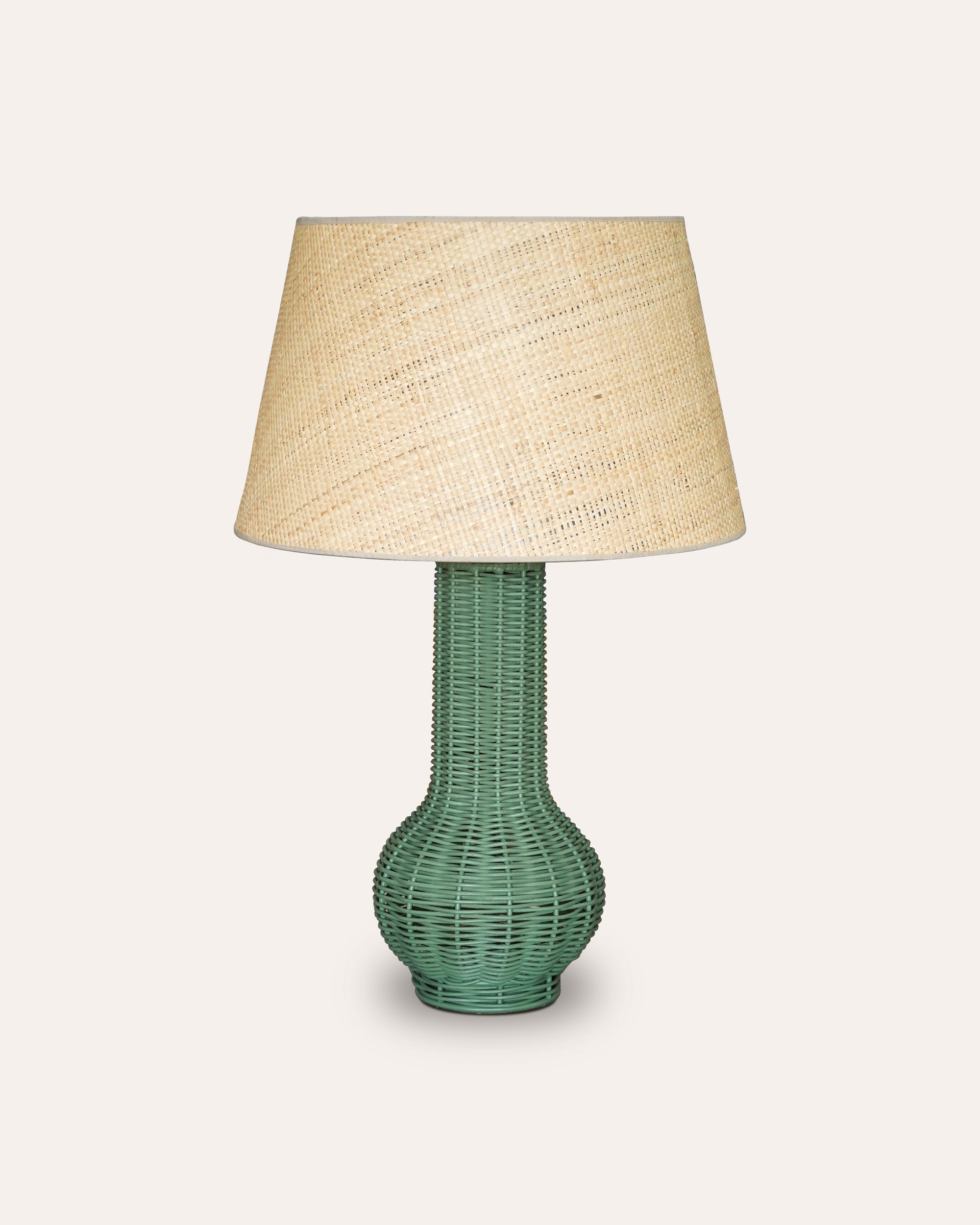 Green Surahi rattan table lamp paired with a natural Seema raffia lampshade on a taupe background