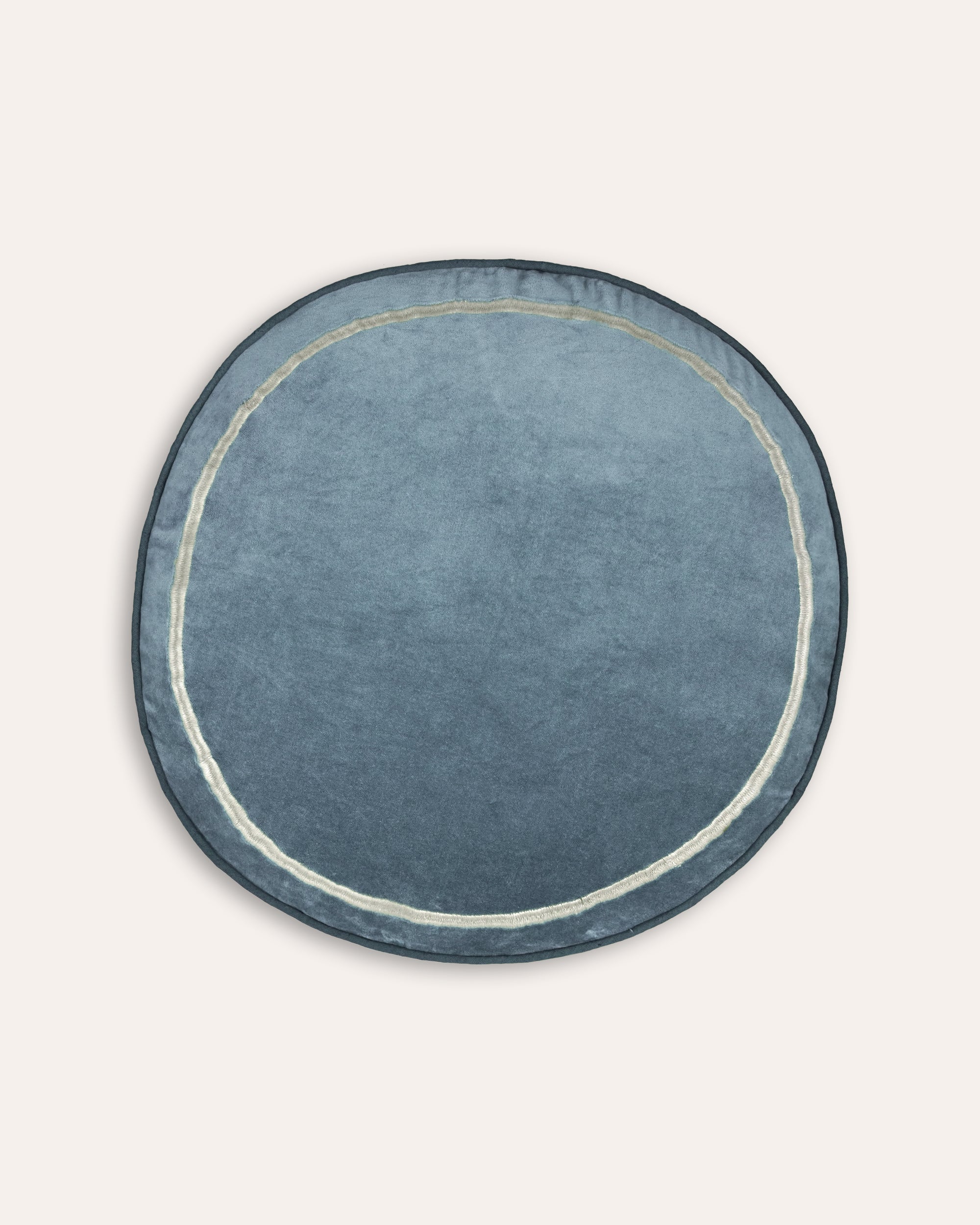 Round blue cushion with a white border on a light grey background