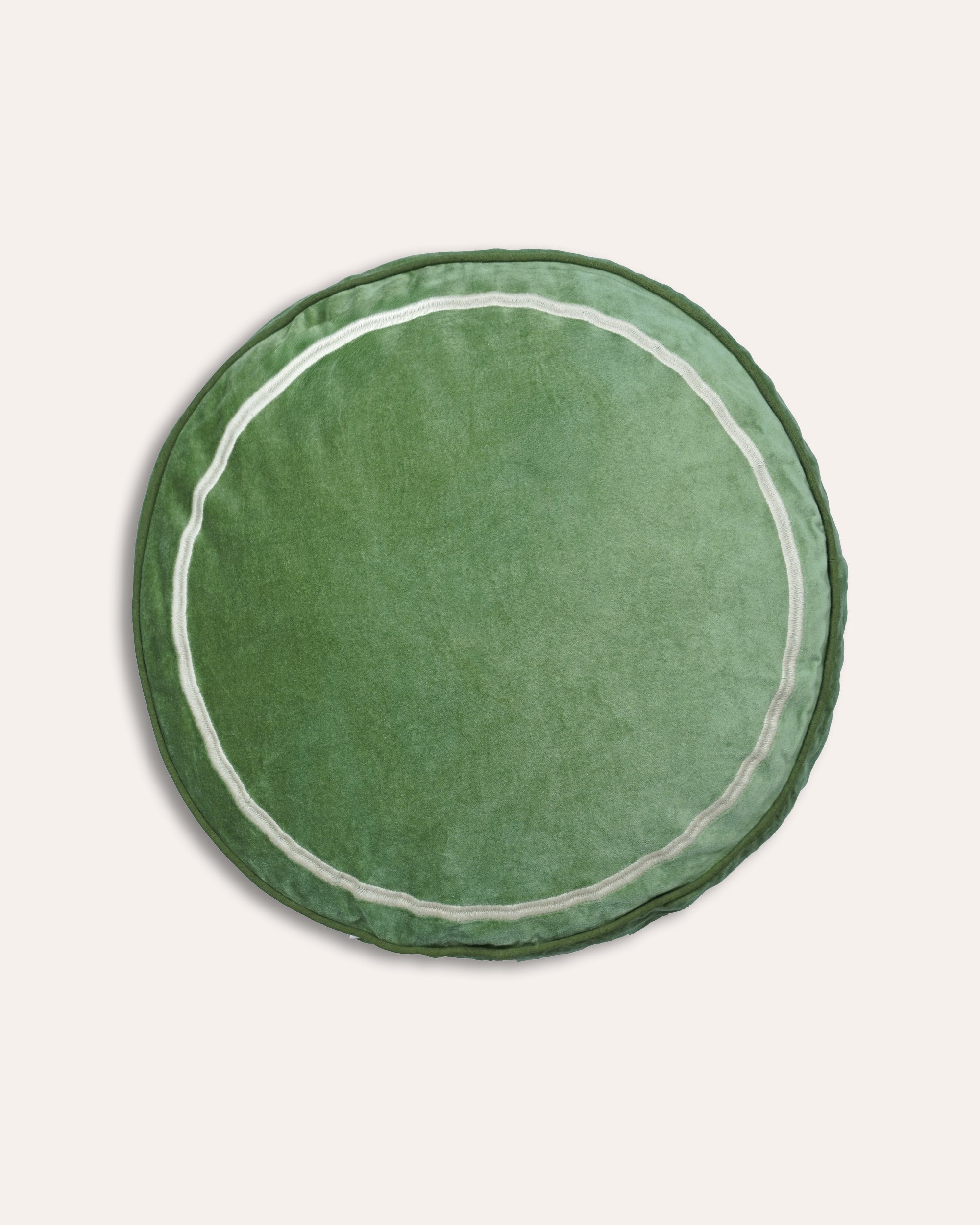 Green round cushion with white trim on a light grey background