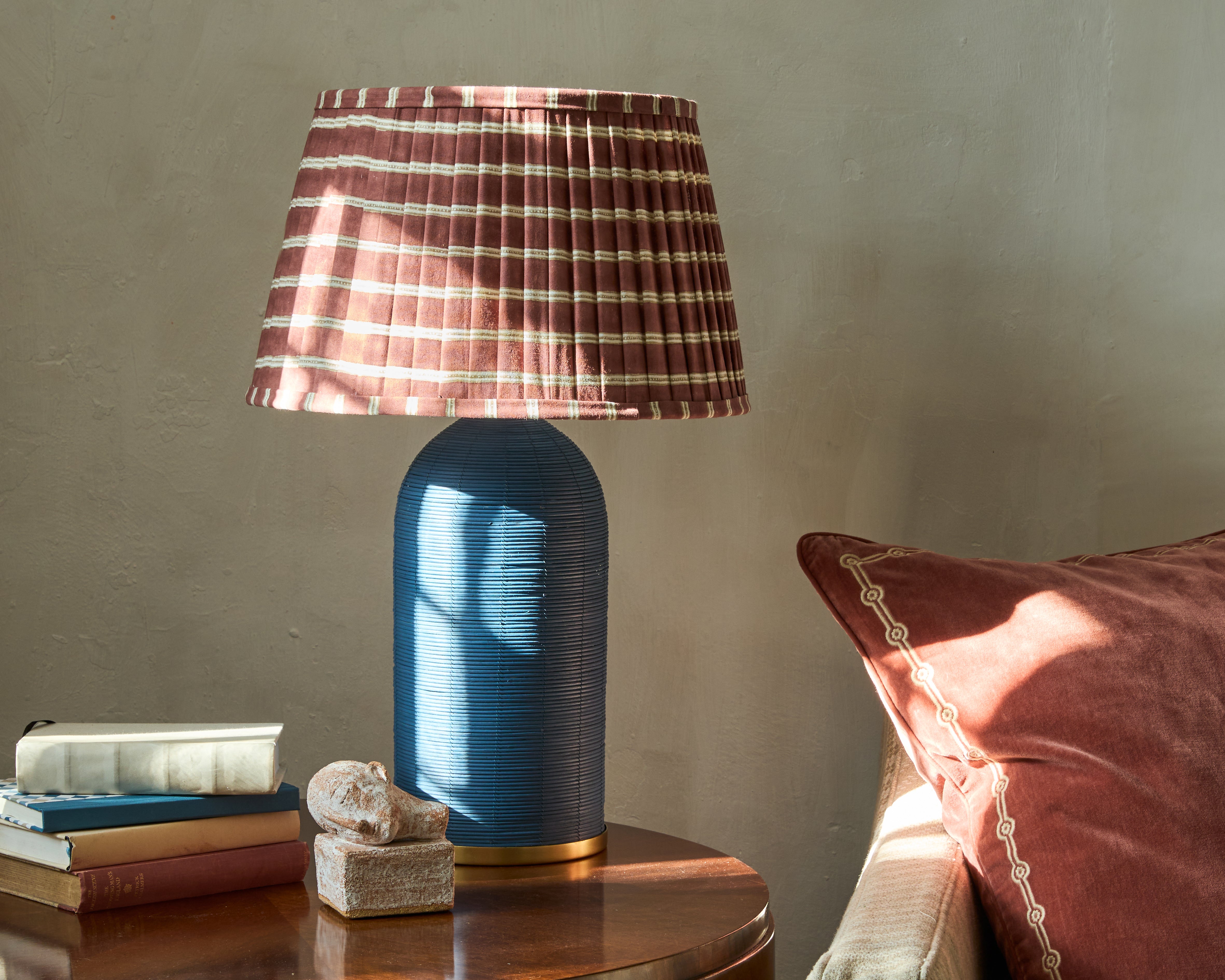 Sunlit lifestyle image of our Edo pleated lampshade on our blue Rattan Table Lamp