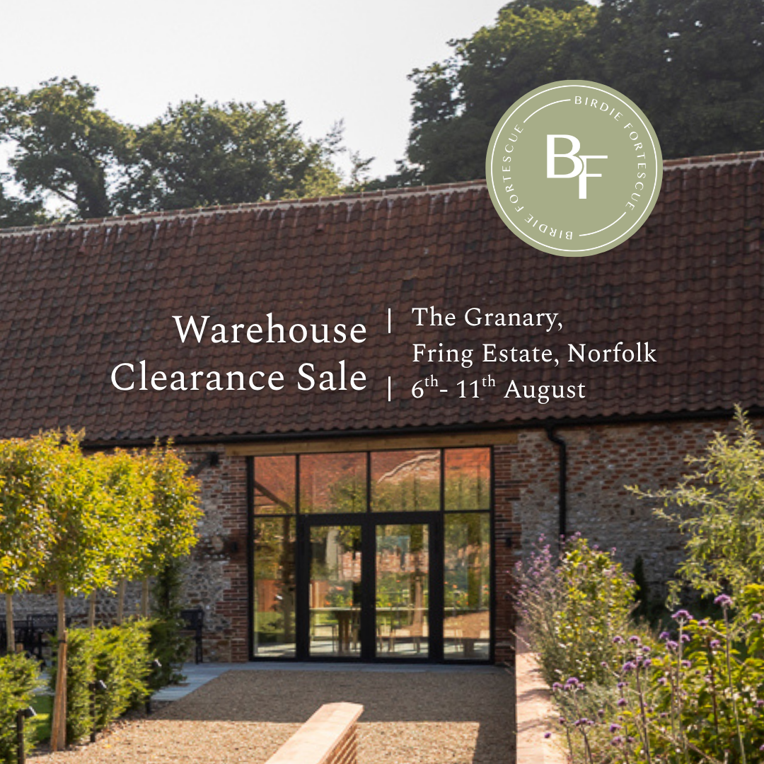 Promotional real estate image for a warehouse clearance sale at The Granary, Fring Estate, Norfolk. The photo shows the brick building with a tiled roof, glass entrance, and landscaped garden.